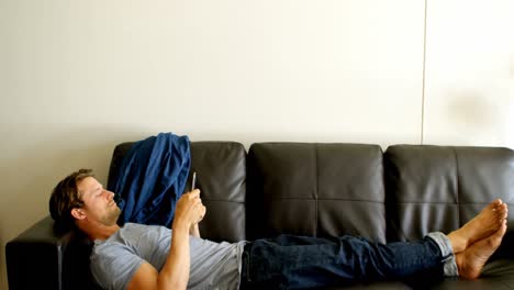 hombre usando teléfono móvil en la sala de estar 4k