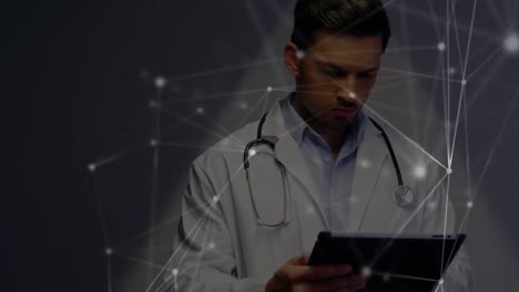 Animation-of-network-of-connections-over-caucasian-male-doctor-using-tablet