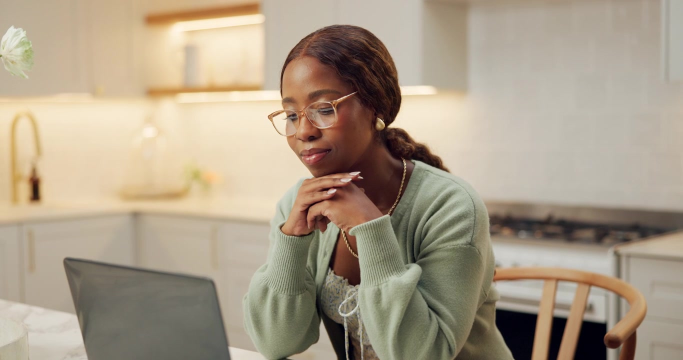Young Woman Working on Laptop in Modern Kitchen
