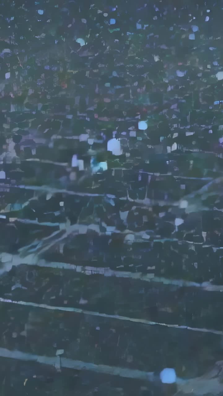 Vertical video: Drifting colorful particles filling dark tiled floor, obscuring panel grid seams