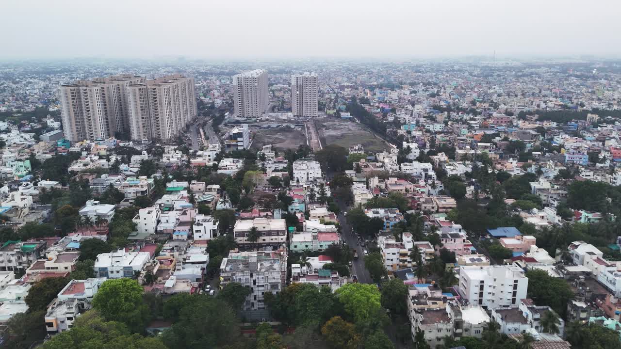 Un'inquadratura aerea di moderni grattacieli in un fitto paesaggio urbano. Un grande appezzamento di terreno non edificato mette in evidenza lo sviluppo immobiliare e la crescita urbana
