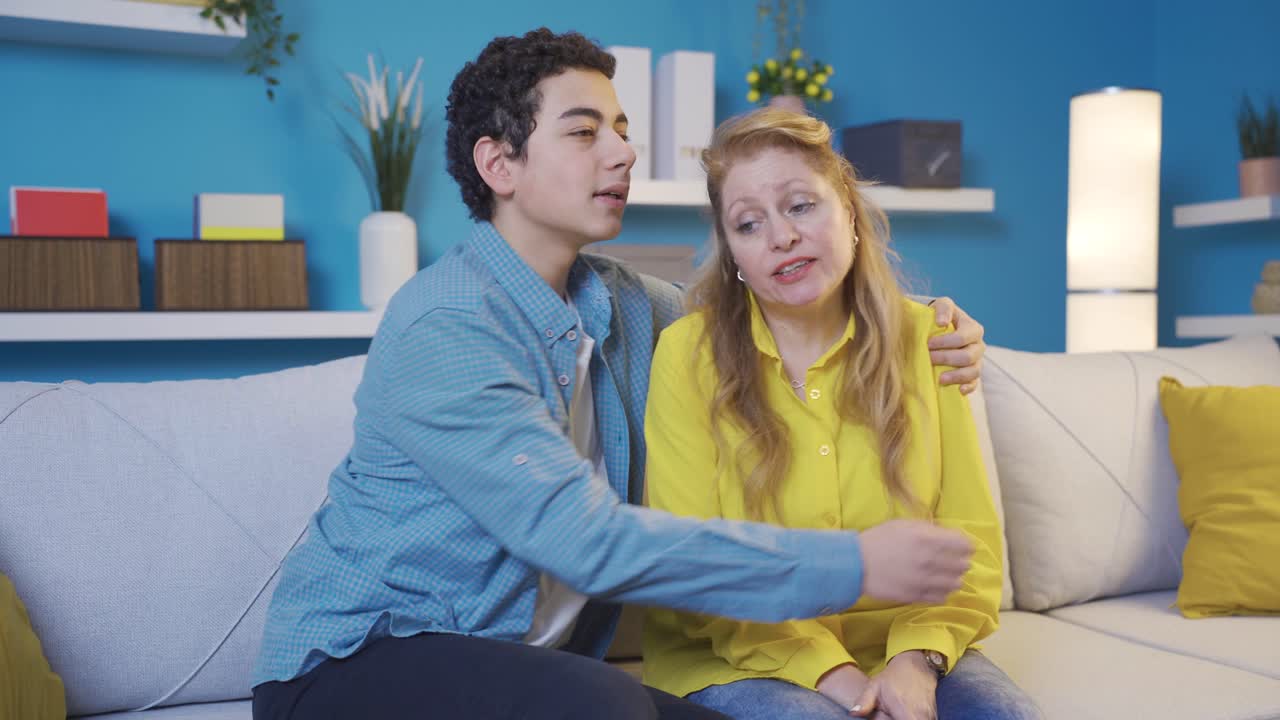 Young man giving morale to his sad and bored mother.