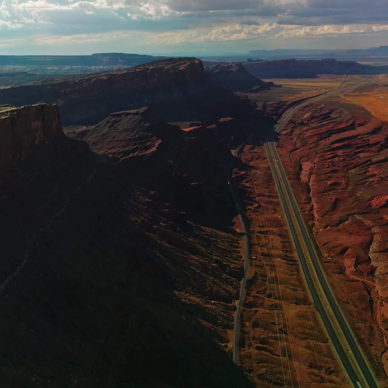 Flying above the motorways at the foot of fascinating canyons. Spectacular view of rocky relief from aerial perspective