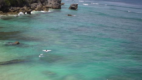 surfer in het water in uluwatu, bali