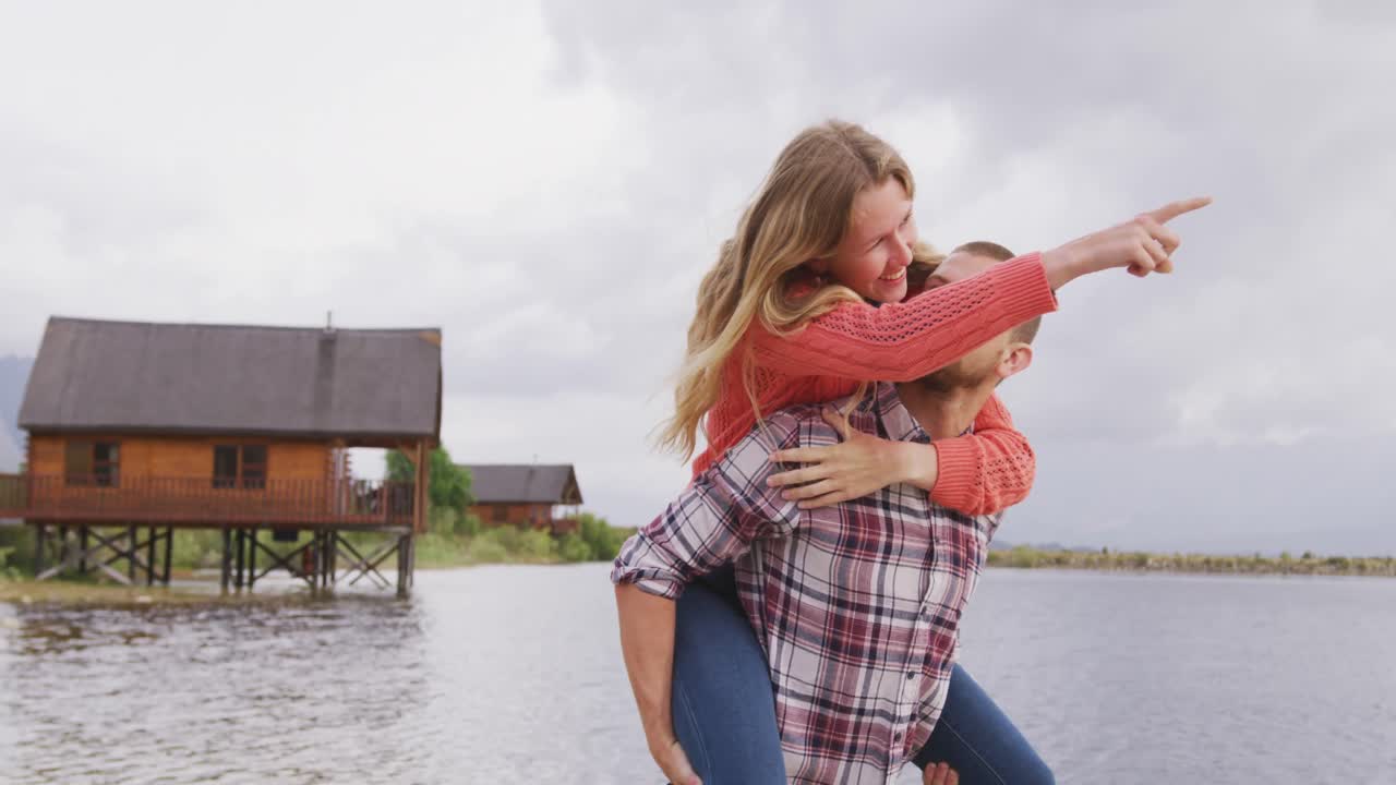 Caucasian couple having a good time on a trip to the mountains, smiling, the man holding the woman