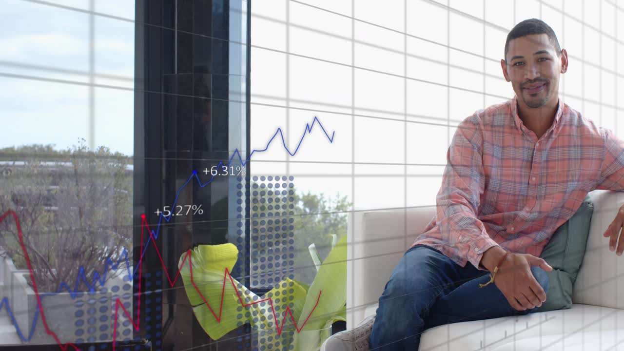 Mid-adult man reacting on white couch by grid window, data update starting, finance charts rising