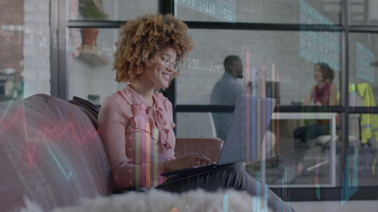 Graphs processing data over happy biracial casual businesswoman using laptop in office