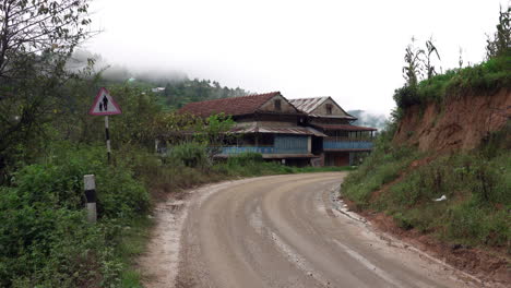 an empty muddy road in the foothills of the himalayas in nepal