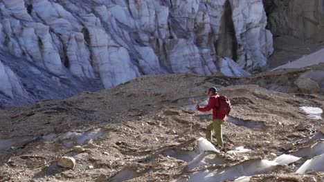 hiker walking over a glacier at high altitude in the andes mountains. cerro gemelos. mendoza, argentina.