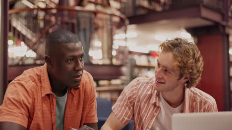 two students studying together in a library