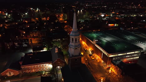 aerial orbit of steeple in dark of night. aerial city establishing shot in usa.