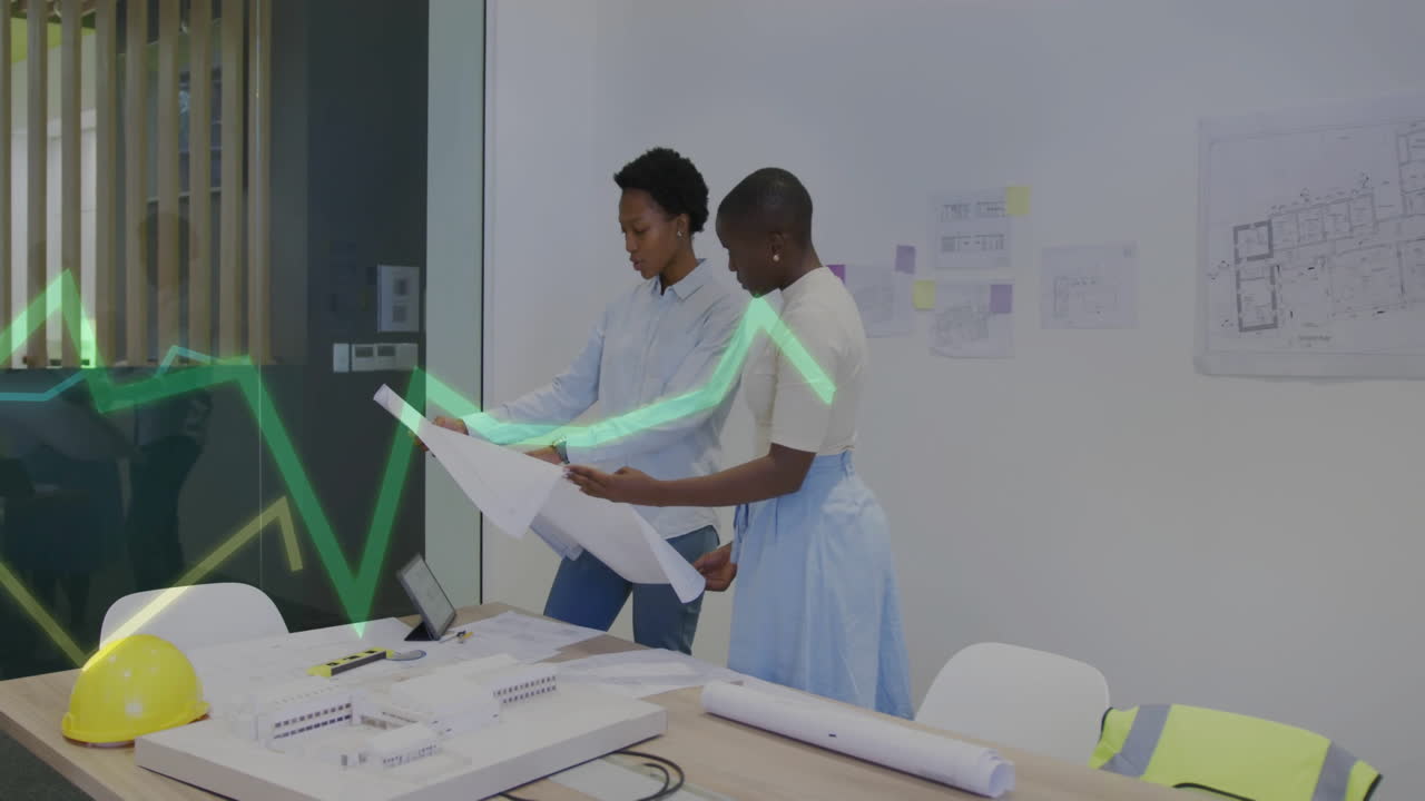 Reviewing architectural blueprints in office, two people with data processing animation