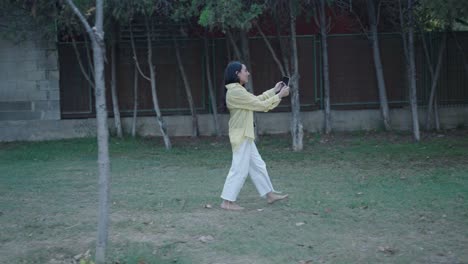woman walking in a park using smartphone