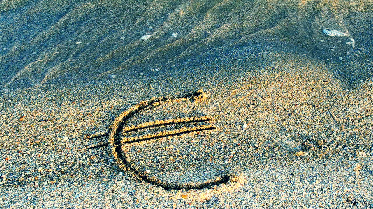 Euro sign on sand. Sand and currency