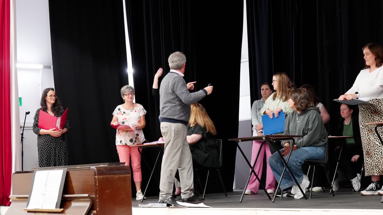 Artistic director giving instructions to female performing stage group