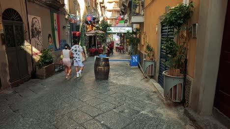 tourists explore a vibrant, narrow street in naples