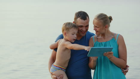 Eltern-Und-Kleiner-Sohn-Mit-Pad-Am-Meer