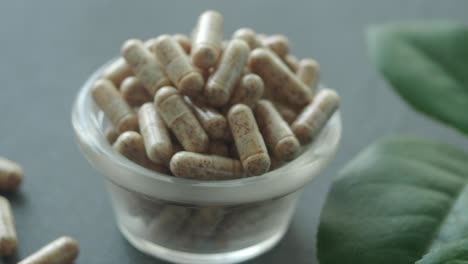 natural dietary supplement capsules in glass bowl