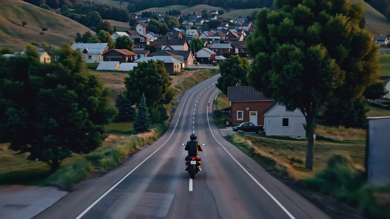 마을 을 가로질러 경치 좋은 시골 도로 에 있는 오토바이 운전자