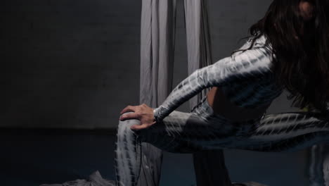 close up of a woman focused in warming up and stretching her body before yoga at her studio