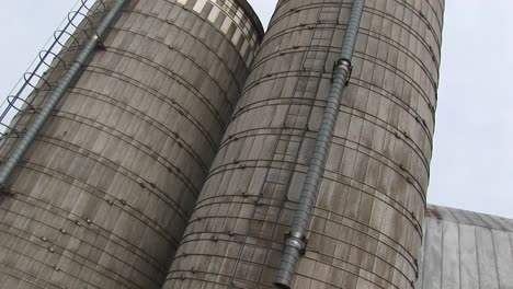 camera pans up the sides of two grain silos