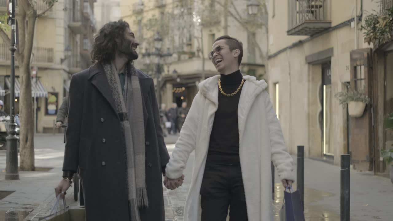 Gay couple walking and holding hands on a city street
