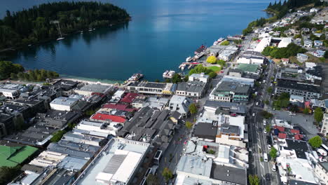 Aufschlussreiche-Luftaufnahme-über-Queenstown,-Neuseeland,-Die-Den-Wakatipu-See-Und-Eine-Bergkette-An-Einem-überwiegend-Sonnigen-Tag-Zeigt