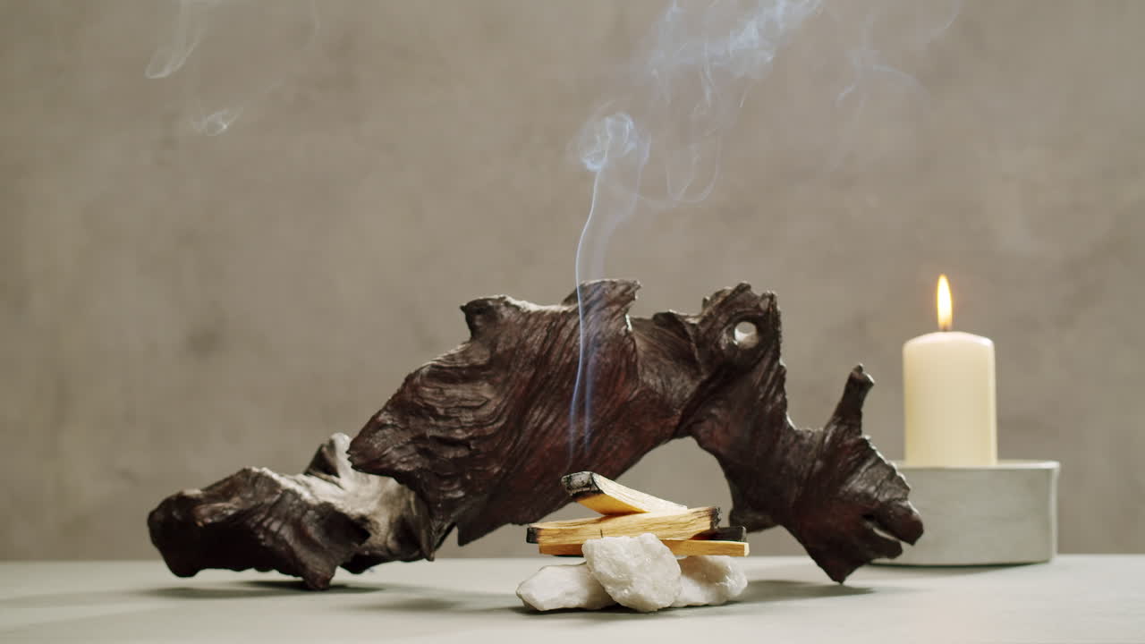 Person holding Palo Santo wood stick in hand, aromatic Palo Santo burning on black background, smoke spreading around, slow motion video clip, high quality 4k close up footage. High quality 4k footage