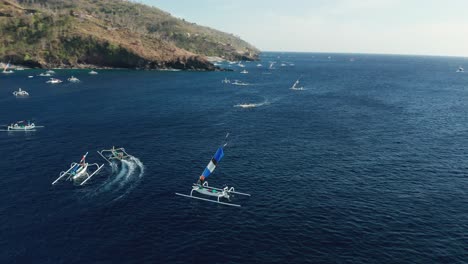 local fishermen on traditional jukung boat taking down crab claw sail, aerial