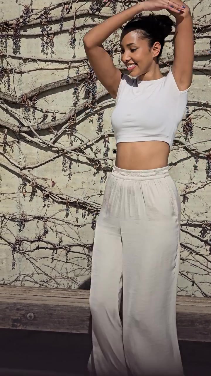Movimento gioioso: una donna che balla elegantemente in abbigliamento casual contro una parete splendidamente strutturata