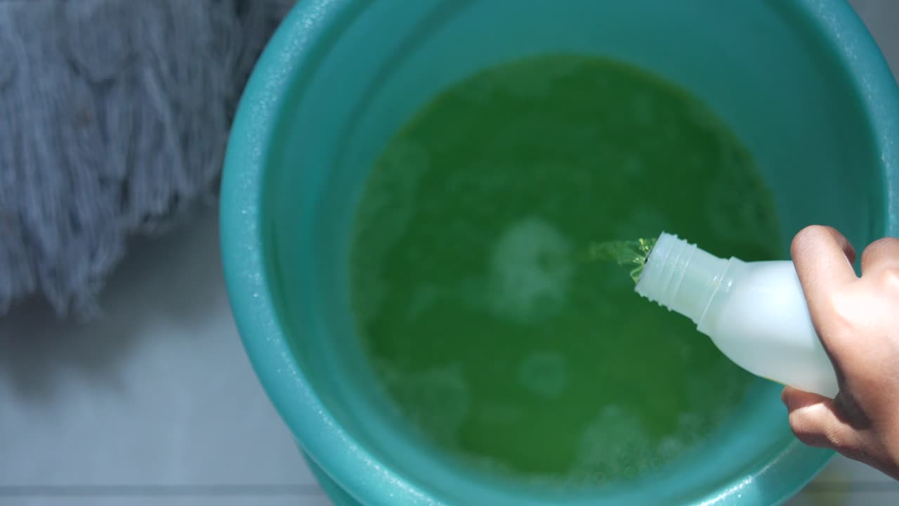 청소 용액을 mop bucket에 부어 넣습니다.