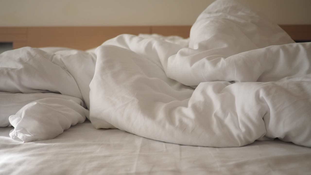 A messy bed with white sheets