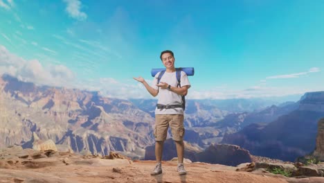 Full Body Of Asian Male Hiker With Mountaineering Backpack Smiling And Pointing To Side While Traveling At The Top Of Mountain