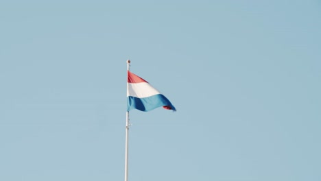 dutch flag in the wind of clear blue sky day