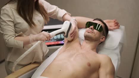 man armpit area during procedure of laser hair removal in modern cosmetology clinic. concept of man beauty, cosmetology, epilation