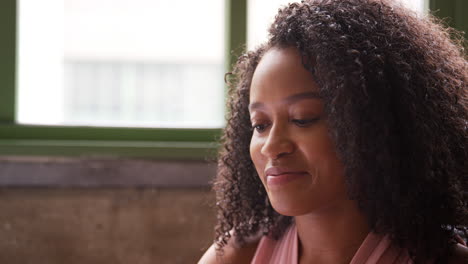 young black woman uses computer, head and shoulders close up