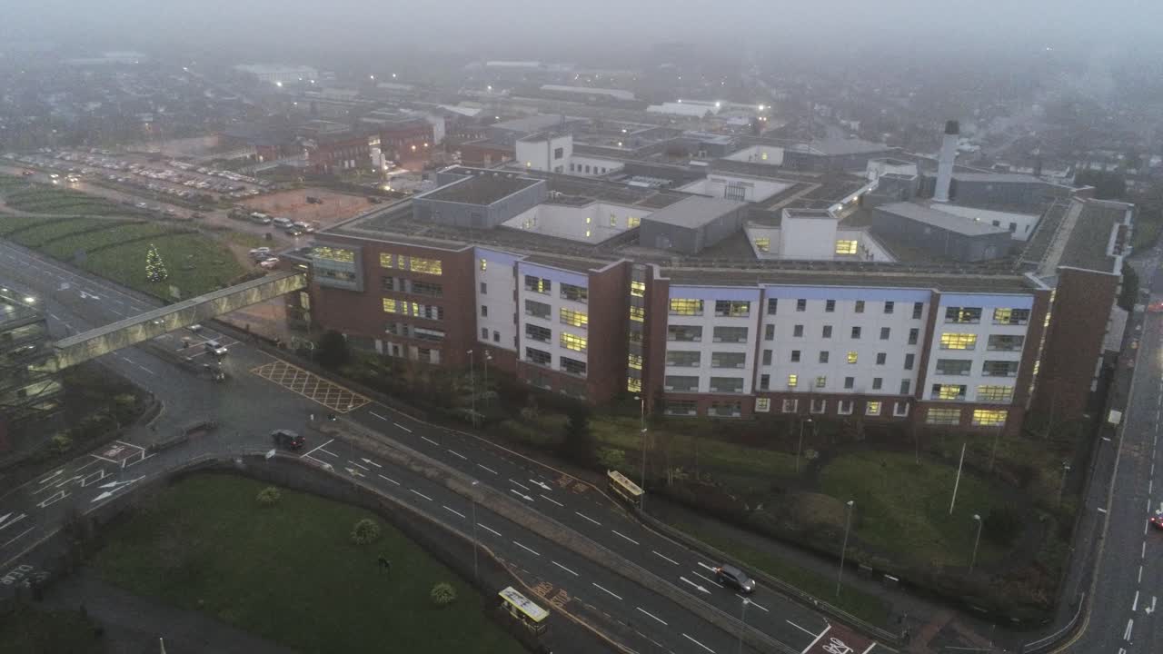 vista aérea del hospital británico nhs en misty mojado húmedo mañana alta órbita lenta derecha