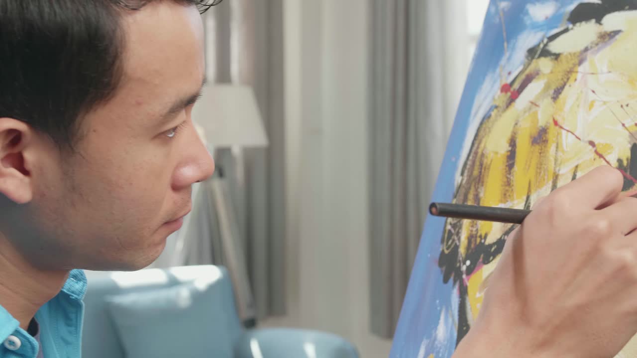 Close Up Side View Of An Asian Artist Man Holding Paintbrush Mixed Colour And Thinking Before Painting A Girl'S Face On The Canvas