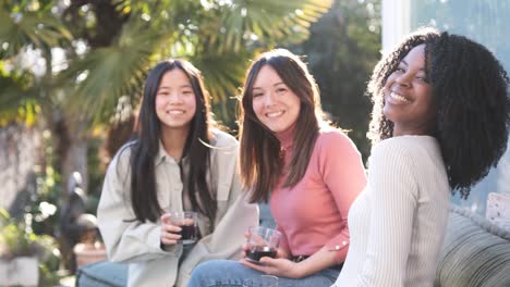 diverse girlfriends drinking beverages on terrace
