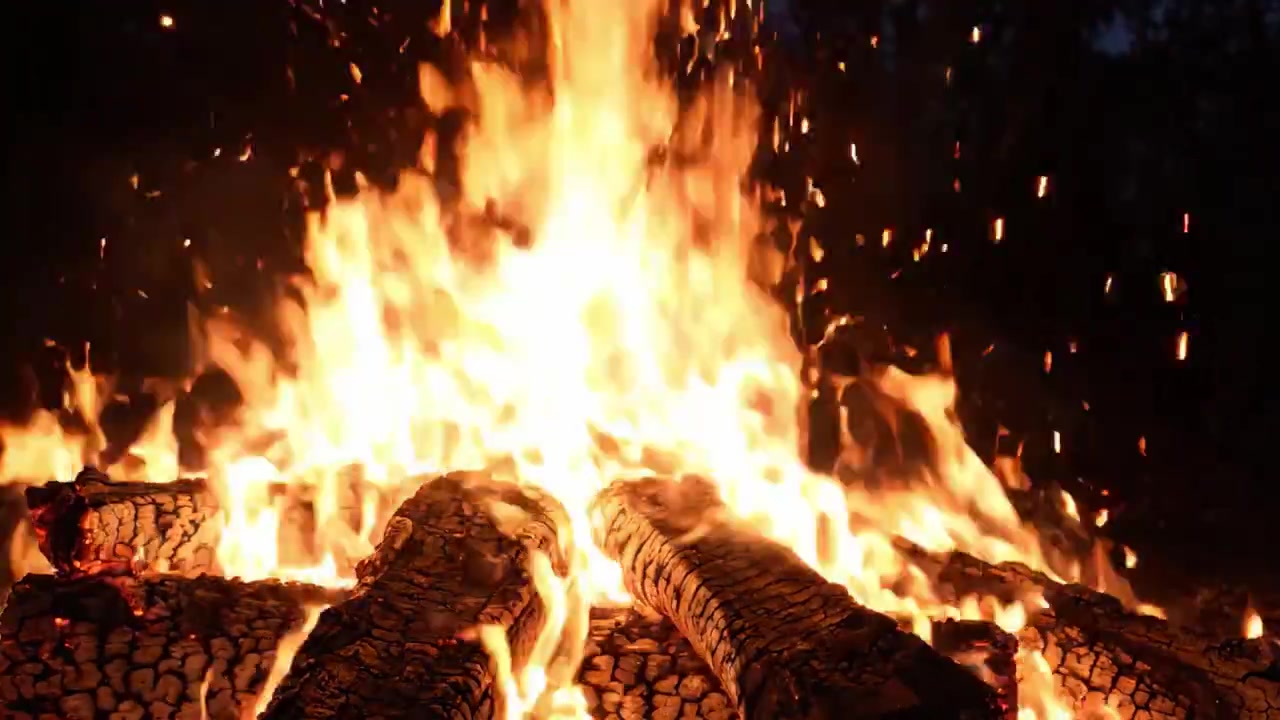 Una spettacolare dimostrazione della potenza della natura: le fiamme danzanti di un maestoso falò illuminano il cielo notturno con ceppi incandescenti e ceneri scintillanti.
