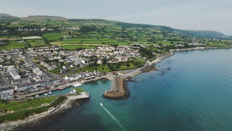 Static-aerial-shot-of-small-boat-sailing-into-harbor-marina---Northern-Ireland