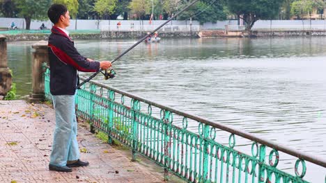 man fishing at a pond in hanoi, vietnam