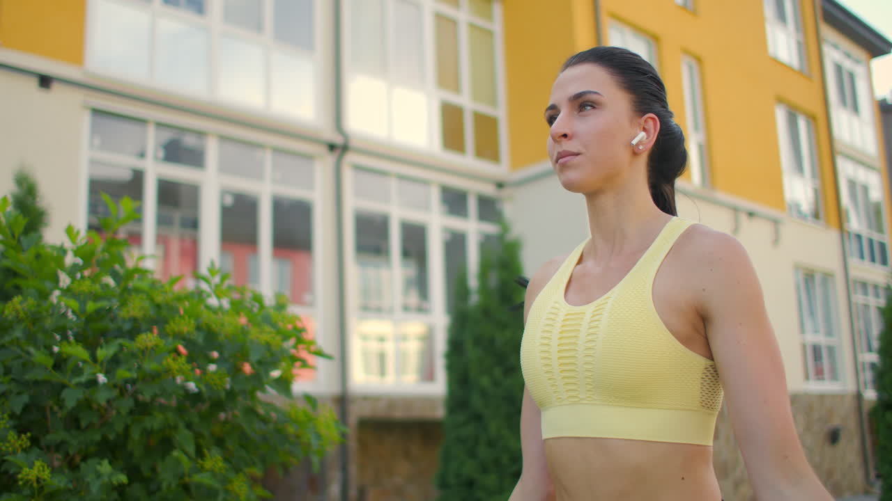 Training a young woman to jump rope against a house in an urban ...