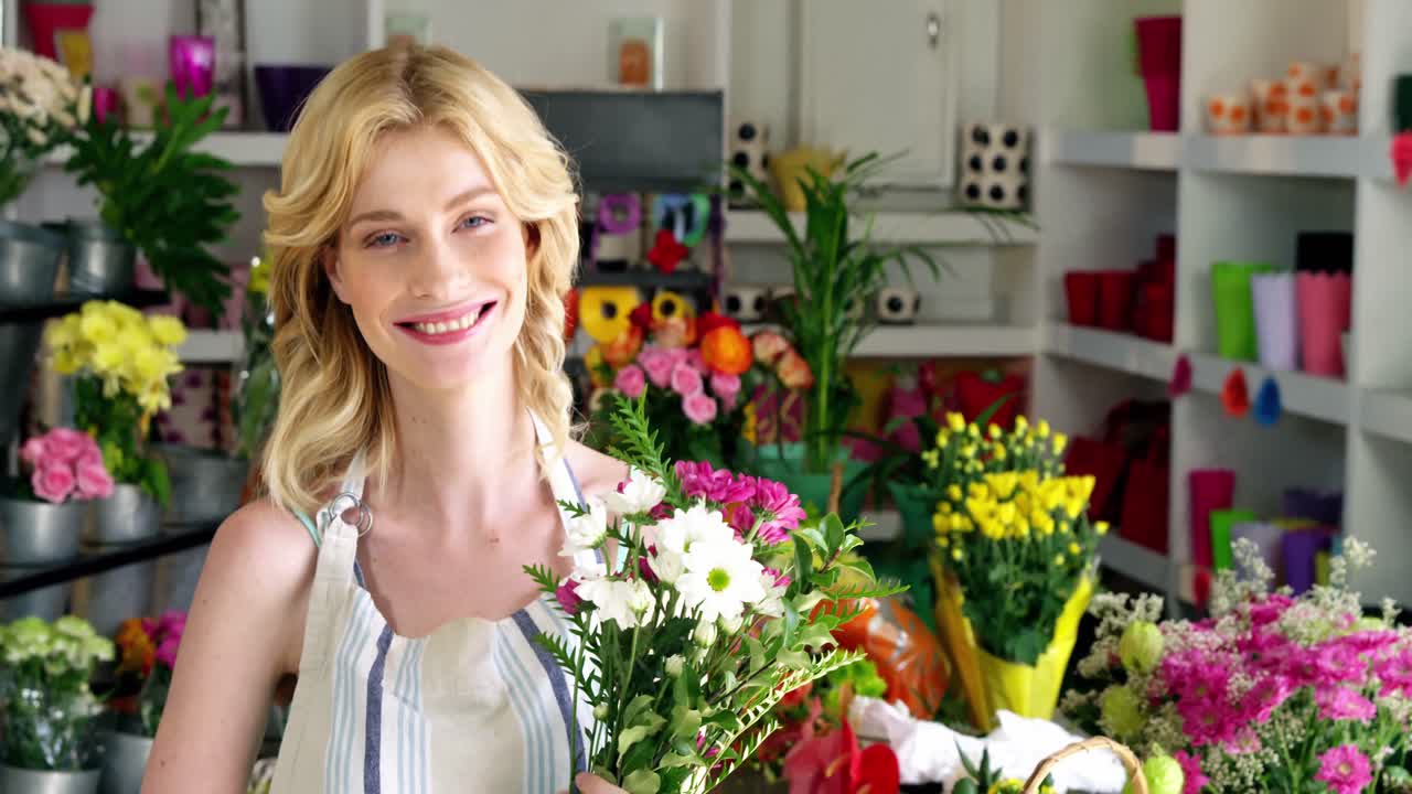 Fiorista che tiene in mano un mazzo di fiori in un negozio di fiori