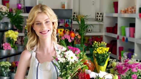 Female-florist-holding-bunch-of-flowers-in-flower-shop