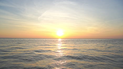 Wunderschöner-Sonnenuntergang-über-Dem-Meer-Mit-Sonne-Nahe-Dem-Horizont,-Sonnenreflexion-Auf-Sich-Bewegenden-Wellen