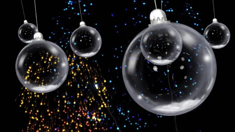 animación de bolas de navidad colgando sobre fuegos artificiales explotando sobre un fondo negro