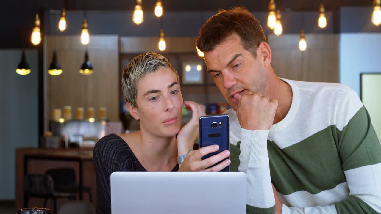 ejecutivo discutiendo por teléfono móvil en el café 4k