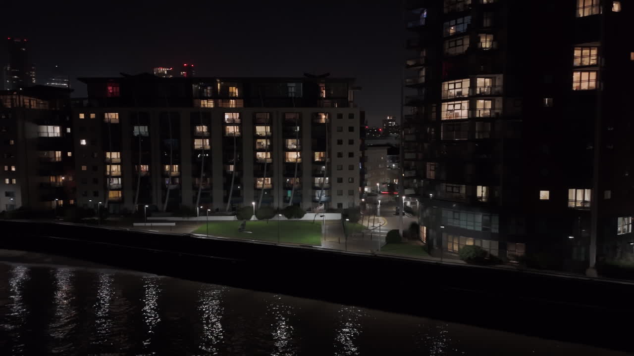 Aerial tracking shot of apartments on the Isle of Dogs, night in London, UK