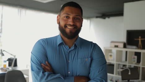 Smiling-handsome-man-posing-with-crossed-arms-in-office.